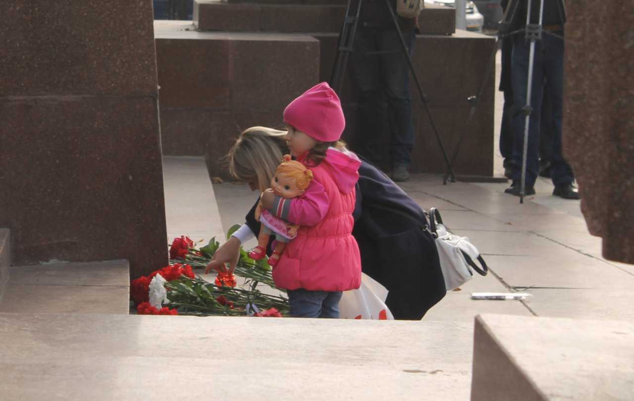 На площадь Ленина приходят люди и возлагают цветы в память о погибших в Керчи