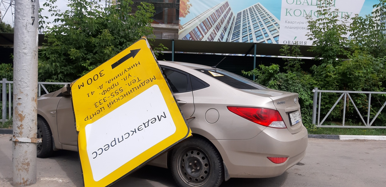 На улице Дзержинского на припаркованный автомобиль упал рекламный знак