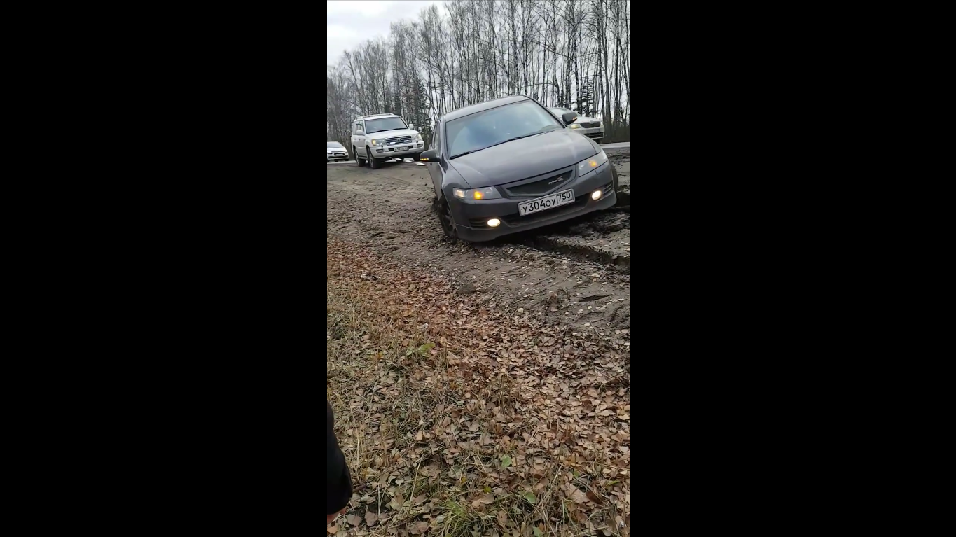 Как внедорожник вытаскивал застрявший в грязи на обочине автомобиль - видео
